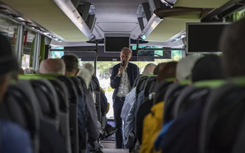 Passengers of boutique river cruise ship MS Thurgau Saxonia (Thurgau Travel) on excursion bus with guide speaking, Berlin, Berlin, Germany