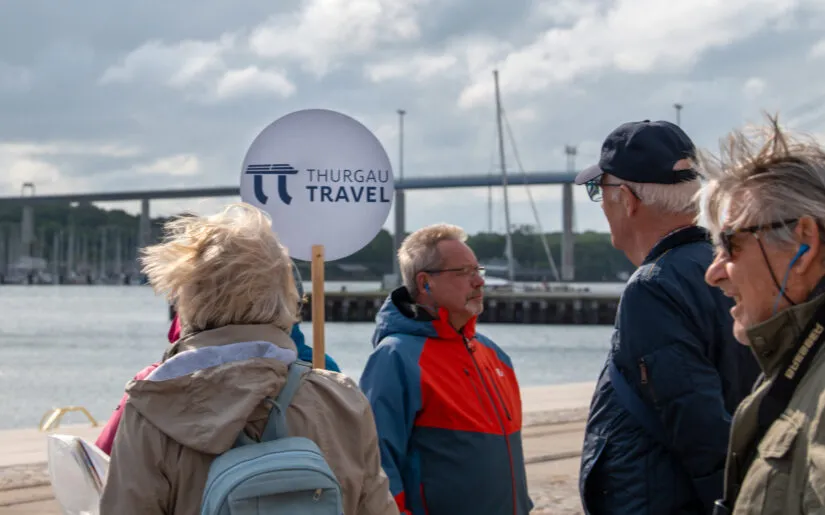 Guide with tour sign and passengers from boutique river cruise ship MS Thurgau Saxonia (Thurgau Travel) during excursion, Stralsund, Mecklenburg-Western Pomerania, Germany
