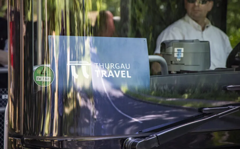 Thurgau Travel excursion sign with reflection in windshield of tour bus, Chorin Sandkrug, Brandenburg, Germany