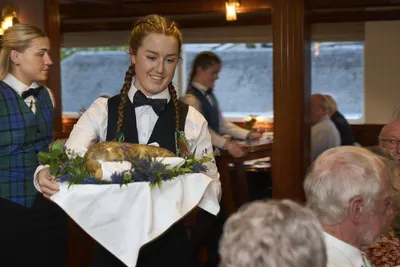 flusskreuzfahrt thurgau-gala-dinner lord of the highlands Eine Kellnerin serviert ein Gala-Dinner auf dem Flusskreuzfahrtschiff