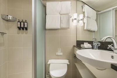 Flusskreuzfahrt MS Edelweiss Thurgau Bad Das moderne Bad auf dem Flusskreuzfahrtschiff MS Edelweiss von Thurgau Reisen. Es zeigt ein elegantes Lavabo mit einem stilvollen Wasserhahn, Handtüchern und Pflegeprodukten, die sorgfältig angeordnet sind. Die hellen Fliesen und die geschmackvolle Beleuchtung schaffen eine angenehme und einladende Atmosphäre.
