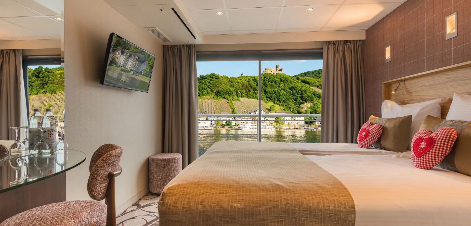 Edelweiss gemütliche Kabine Kabine der MS Edelweiss mit Panoramafenster und französischem Balkon mit Ausblick auf Stadt am Flussufer.