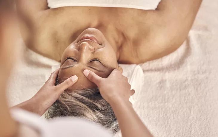 © LuneVA/peopleimages.com - stock.adobe.com - Head, massage and zen with old woman in spa for vacation, luxury and beauty salon. Peace, wellness and holiday with senior person and hands in hotel villa for retirement, oil treatment and body care
