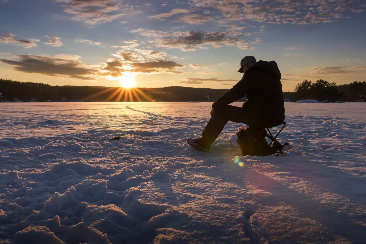 Eisfischen auf einem See in Norwegen bei Sonnenuntergang - ©MarianneHydalsvik - stock.adobe.com