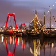 Am frühen Morgen im Alten Hafen, mit historischen Lastkähnen, der Willemsbrücke und der Fassade des „Weißen Hauses“ von Rotterdam