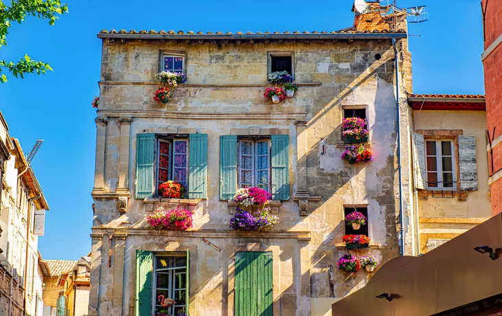 © Acker - stock.adobe.com - Fensterläden und Blumenkästen in Arles