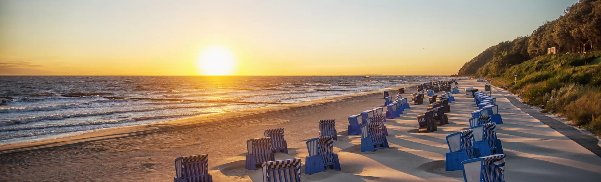 Schatten von Strankörben beim Sonnenaufgang am Strand von Usedom - © Patrick - stock.adobe.com