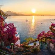 Sonnenaufgang an der Amalfiküste mit blühenden Bougainvillea und Meerblick.