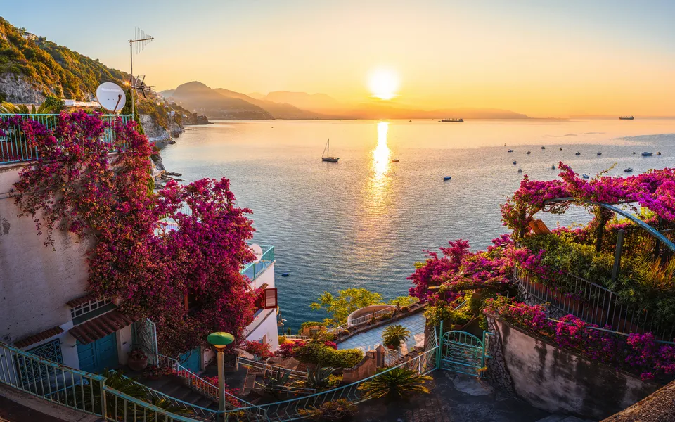 Sonnenaufgang an der Amalfiküste mit blühenden Bougainvillea und Meerblick.