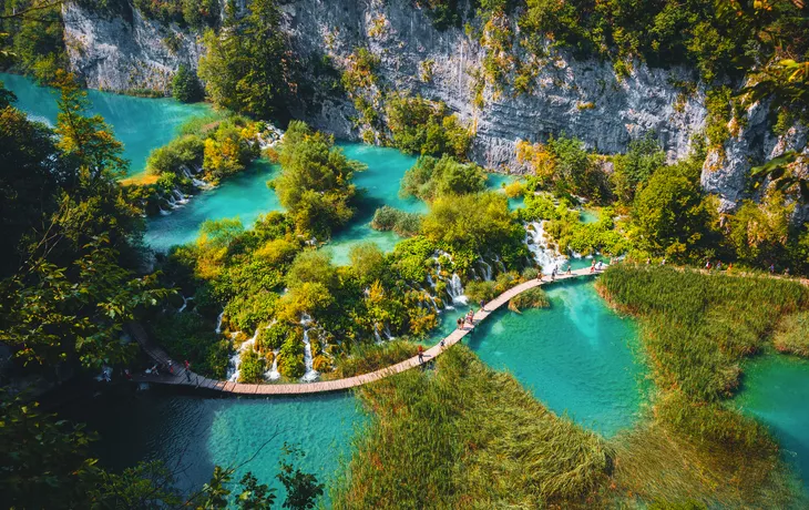 Luftaufnahme eines hölzernen Wanderwegs neben Wasserfällen im Nationalpark Plitvicer Seen - © Leonid Tit - stock.adobe.com
