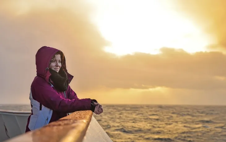 Touristische Mädchen auf einem Boot einen wunderschönen Sonnenuntergang über dem Meer - © icephotography - stock.adobe.com