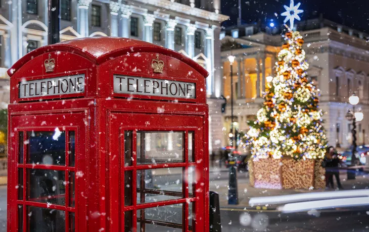 tote Telefonzelle in London vor einem beleuchtetem Weihnachtsbaum zur Adventszeit - © moofushi - stock.adobe.com
